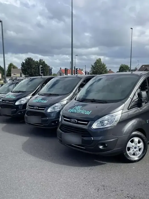 Row of HB Electrical branded vans parked in a car park